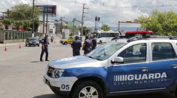 Veículo da Guarda Municipal em primeiro plano, guardas municipais e uma viatura da CET ao fundo, todos controlando o acesso em uma rua. #Paratodosverem