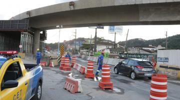 #pracegover Com carro da CET em primeiro plano, foto mostra veículo de passeio trafegando sob o viaduto 