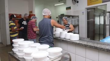 pESSOAS DENTRO DE RESTAURANTE, USANDO TOUCAS E LUVAS PREPARAM MARMITAS DE REFEIÇÕES. #Paratodosverem