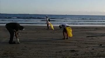 duas pessoas recolhem lixo da praia #paratodosverem 