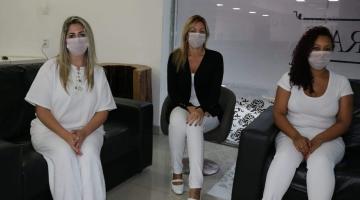 profissionais de saúde sentadas no hotel #paratodosverem 