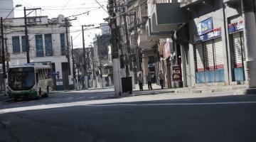 #pracegover Foto mostra rua vazia, com lojas fechadas, no Centro