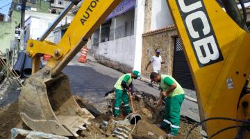 dois homens e máquina atuam em buraco na obra #paratodosverem