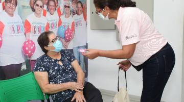 voluntária entrega copo a senhora #paratodosverem 