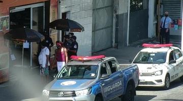 Viaturas da guarda e da polícia militar estão diante de estabelecimento. Há guardas também no local. #Paratodosverem