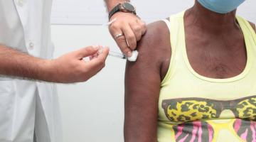 mãos vacinam braço de mulher. #paratodosverem 