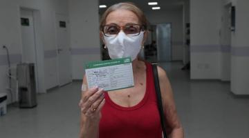 senhora mostra cartão de vacinação #paratodosverem 