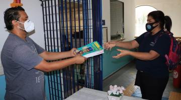 homem entrega caderno a mulher #paratodosverem 