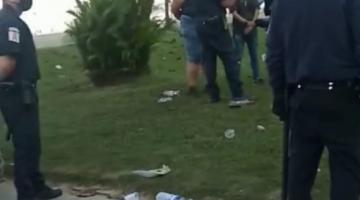 #pracegover Três agentes da guarda municipal abordam grupo de pessoas no jardim da orla pela amnhã