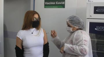 Jovem recebe aplicação da vacina. #paratodosverem