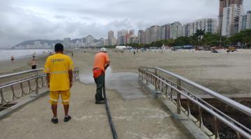 homens limpando pontilhão na praia #paratodosverem