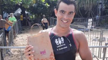 atleta exibe premios na praia #paratodosverem