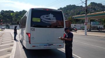 ônibus parado na via sendo abordado por guardas #paratodosverem