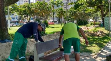 dois trabalhadores realizando serviço no banco da praia #paratodosverem