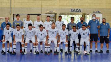 atletas usando uniforme branco , em duas fileiras, abraçados , em uma quadra #paratodosverem