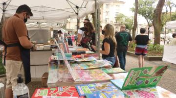 pessoa em uma tenda com livros infantis