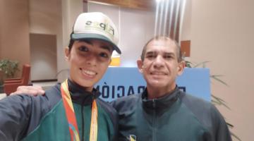 atleta com medalha e professor ao lado #paratodosverem