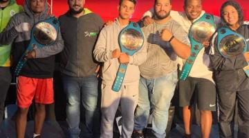 atletas posam para foto com cinturões #paratodosverem