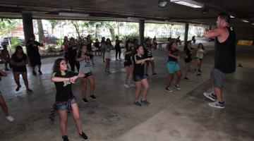 pessoas dançando em frente e um homem #paratodosverem