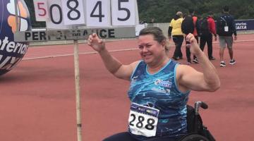 atleta ergue braço comemorando a vitória sentada na cadeira de rodas #paratodosverem