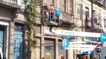 funcionarios fazem serviço em fachada de imóvel #paratodosverem