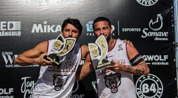 dois atletas beijando troféus #paratodosverem
