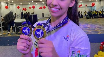 atleta mostra duas medalhas no peito #paratodosverem