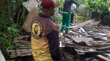 Homens carregam madeira com chão com várias espalhadas #paratodosverem