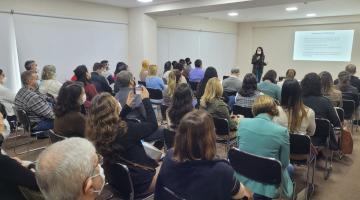 pessoas sentadas em auditório acompánhando palestra #paratodosverem