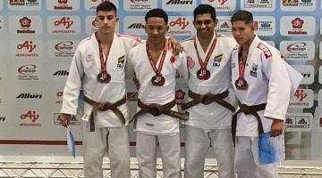 judocas no pódio com medalhas #paratodosverem