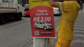 homem retira cartaz preso em poste #paratodosverem