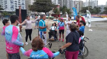 pessoas em circulo na praia de mãos dadas #paratodosverem