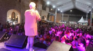 artista canta no palco e muitas pessoas assistem #paratodosverem