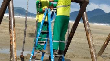 homens instalam equipamento na praia #paratodosverem