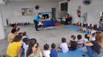 crianças sentadas acompanham teatro de fantoche #paratodosverem