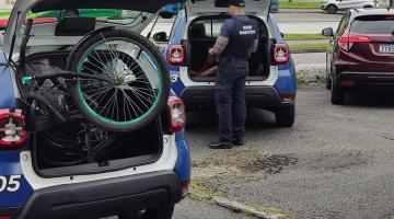 duas viaturas da guarda municipal, ambas com o capô aberto. Em uma delas há uma bicicleta. #paratodosverem