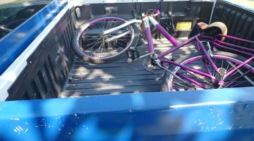bicicleta cor de rosa está dentro de caçamba de veículo. #paratodosverem