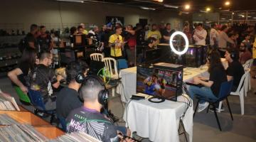 desenvolvedores de games reunidos em sala. vários deles usam fones. há computadores sobre algumas mesas. #paratodosverem 
