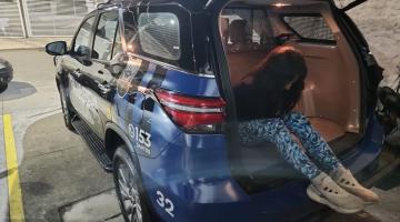 mulher está saindo do porta-malas de viatura da guarda municipal. Não se vê o rosto. #paratodosverem 