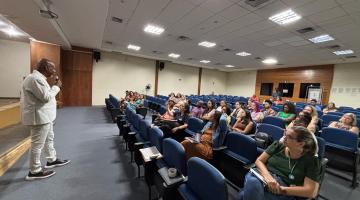 palestrante fala em pé ao auditório #paratodosverem 