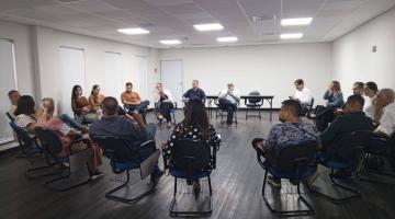 pessoas sentadas e reunidas em roda em salão. #paratodosverem 