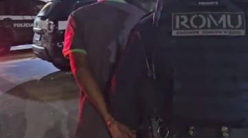 homem é conduzido por guarda municipal. Ambos estão de costas. #paratodosverem
