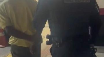 guarda conduz homem de costas para a foto. #paratodosverem