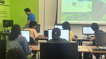 alunos em sala de aula com telão e professor. #paratodosverem