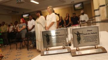 cerimonia com troféus em primeiro plano #paratodosverem 