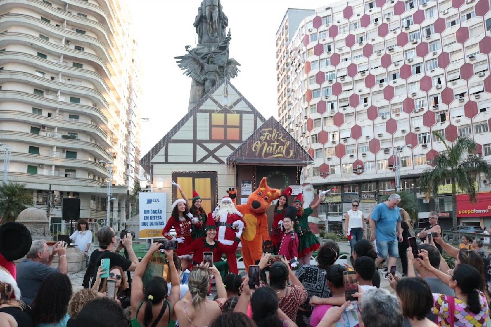 Papai noel e personagens se apresentam na frente da casa #paratodosverem 