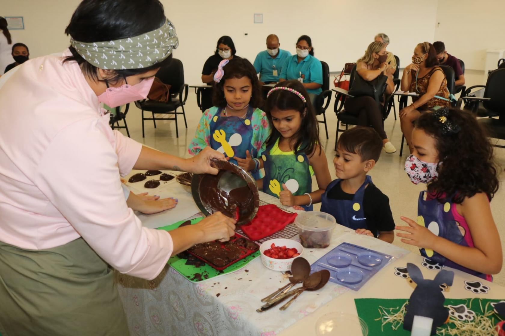 chef mostra a crianças como fazer ovo de chocolate #paratodosverem