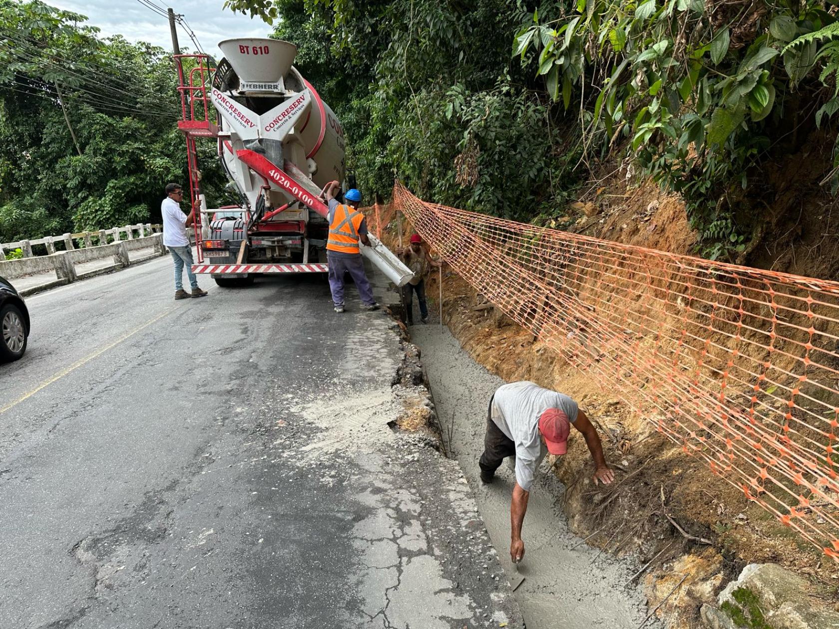 operários e máquina atuando em encosta de morro #paratodosverem