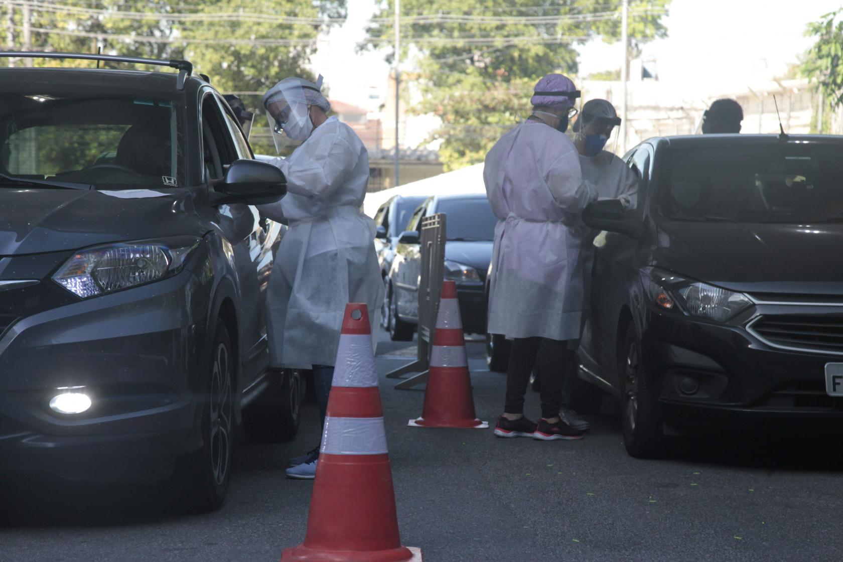 técnicos fazem exames em motoristas em carros em fila #paratodosverem 