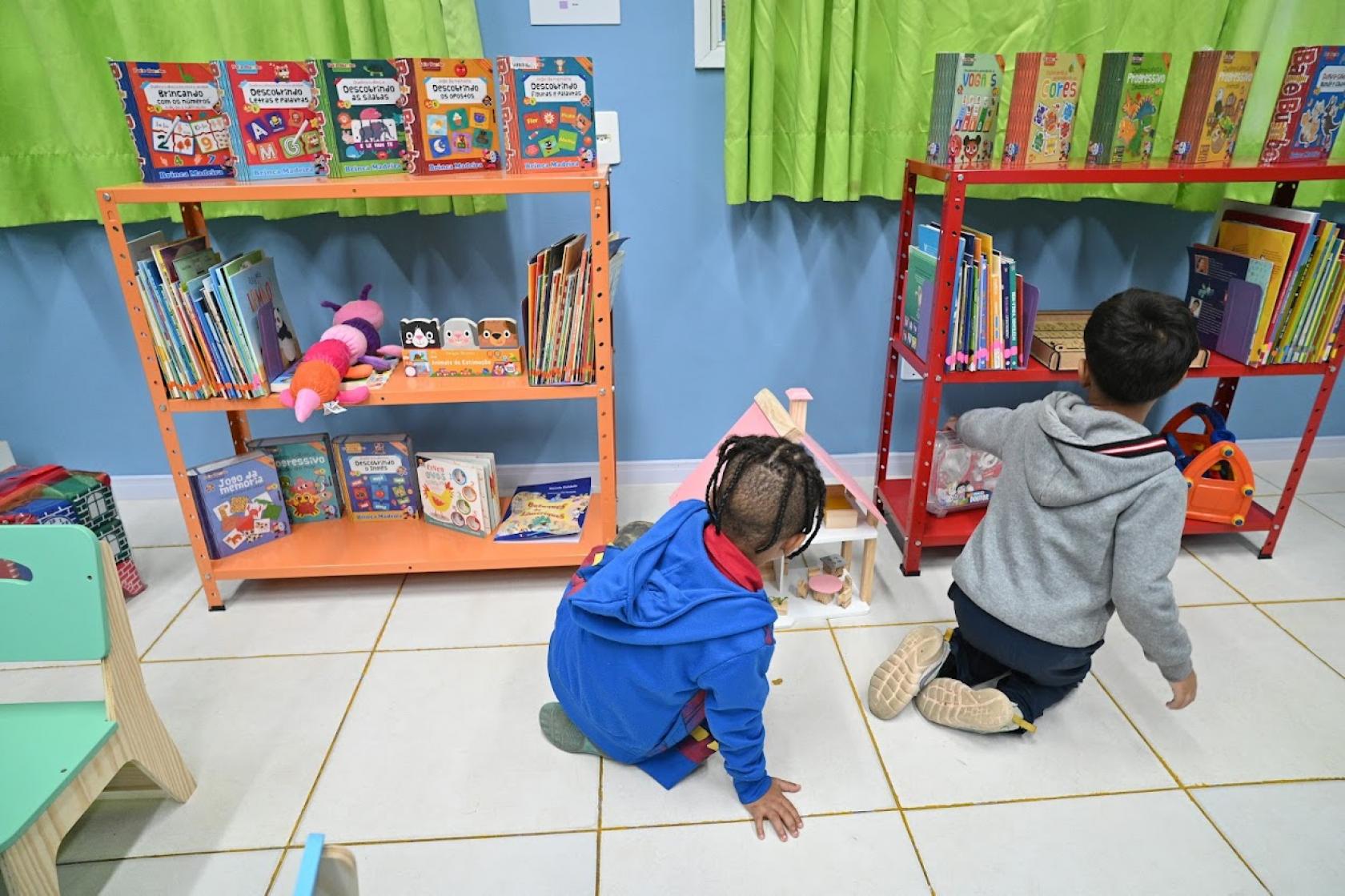 crianças olham livros #paratodosverem